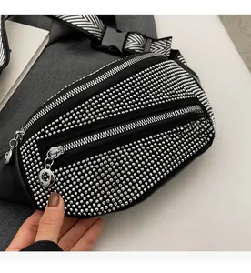 Detail of studded black waist bag with smooth metal double zippers and woven shoulder strap