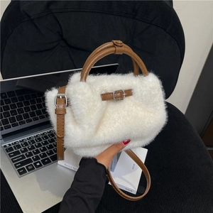 Détail du sac en peluche blanche avec bandoulière en cuir marron et boucle en métal