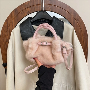 Détail du sac à bandoulière en fausse fourrure rose avec sangle et poignée en cuir