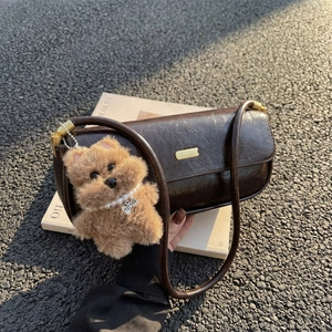 Deep brown vintage baguette bag in oily leather with a cute poodle plush charm