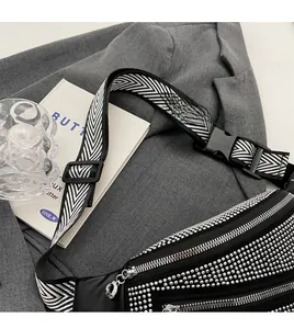 Detailed view of black rhinestone fanny pack with stylish wide patterned shoulder strap