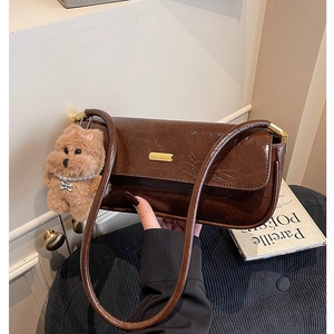 Deep brown oil wax leather baguette bag with gold buckle and a cute plush dog charm