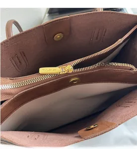 Detail view of brown faux leather tote with multiple compartments and gold hardware