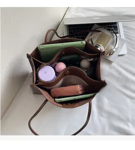 Interior detail of large brown tote bag showing dual compartments and storage capacity
