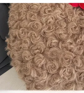 Macro detail of brown curly faux shearling fabric with spiral fleece texture
