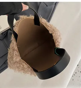 Macro view of plush khaki bucket bag interior with wide space and black leather handles