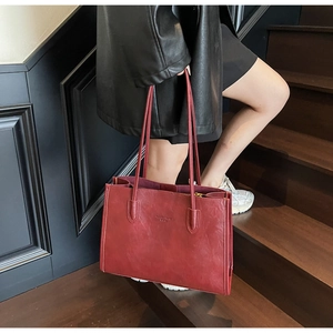 Detail of vintage red PU leather tote bag with Fan Wei Le Fang brand logo and shoulder strap