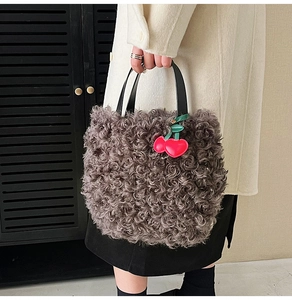 Grey curly faux fur bucket bag with black leather handle and red cherry charm detail