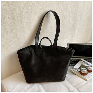 Detailansicht der schwarzen matten Shopper-Tasche mit Wildledertextur und Büro-Accessoires