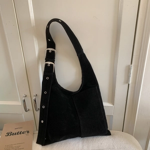 Vintage black suede hobo shoulder bag with metal grommets and adjustable strap in ins style