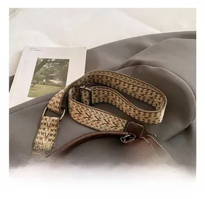 Detail of retro brown leather bag featuring an ethnic geometric woven adjustable strap
