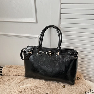 Large black glossy leather tote bag with gold buckle and spacious interior for daily use