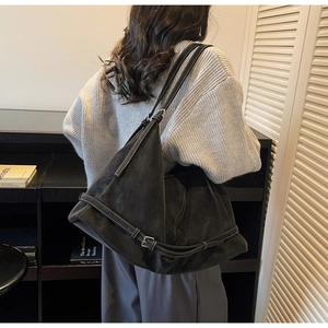 Detail of vintage suede shoulder bag with contrast stitching and metal buckle strap