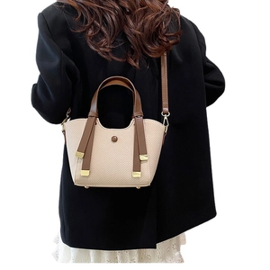 Retro woven beige tote bag with brown leather straps shown on a female model