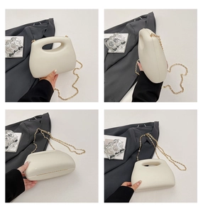 Detail view of cream acrylic box bag with gold chain strap and modern sleek design