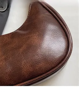 Detailed macro view showing the brown vintage lychee leather texture and fabric lining