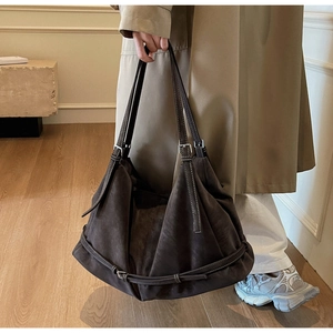Detailed view of dark brown suede tote bag with matte texture and silver buckle