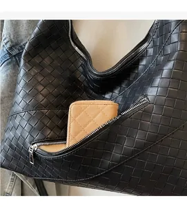 Detail of black woven tote bag featuring a practical exterior zipper pocket for storage