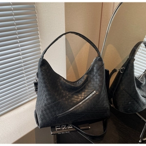 Close-up of black woven hobo bag with silver zipper detail and detachable strap