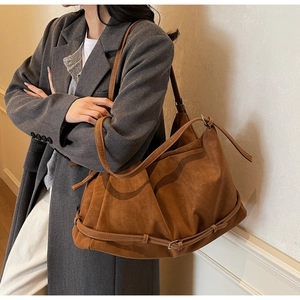 Detail of vintage brown suede hobo bag with adjustable strap and silver metal buckle