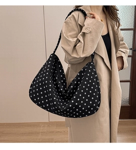 Close-up of hobo style canvas tote bag with classic black and white polka dot pattern
