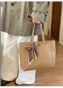 Detail view of khaki tote bag with litchi texture leather and decorative silk scarf accent