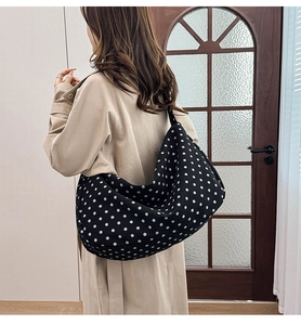 Detailed view of the black canvas tote bag with white polka dots and spacious interior