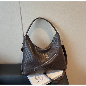Detail of dark brown woven leather bag with decorative zipper and detachable shoulder strap