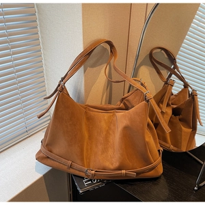 Macro detail of brown suede tote bag with stylish strap design and soft pleated texture