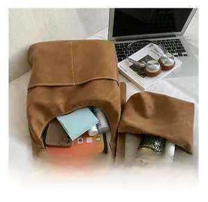 Interior view of large brown faux suede tote bag and matching pouch with modern accessories