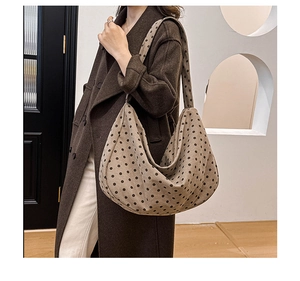 Close-up of a large polka dot tote bag worn with a stylish brown coat for daily commute