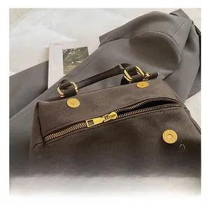 Detail of high-quality golden metal zippers and hardware on a vintage brown messenger bag