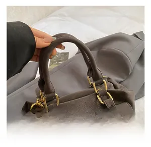Detail of vintage brown messenger bag featuring retro metal buckle and textured leather