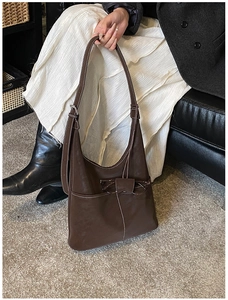 Brown leather hobo bag with contrast stitching and unique eyeglass hanging loop detail
