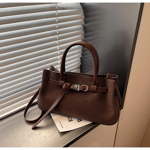 Detail of vintage brown matte leather tote bag with silver buckle and adjustable strap