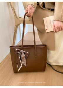 Detail of brown litchi pattern leather tote with floral silk scarf on the handle