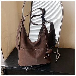 Detail of dark brown hobo bag with contrast stitching and textured lychee pattern leather
