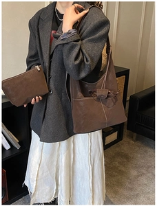 Detail of dark brown faux suede tote bag with matching pouch on a fashion model