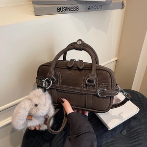 Retro dark brown suede underarm bag with white stitching and plush bunny charm