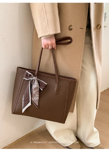 Brown lychee leather tote bag with decorative floral silk scarf on the handle detail