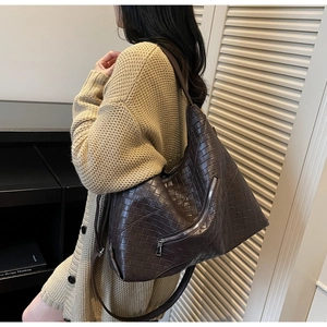 Detail of dark brown woven texture handbag with silver zipper and large capacity design
