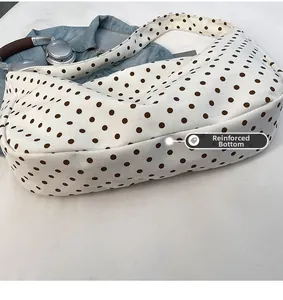 Detailed macro view showing the reinforced bottom design of this large polka dot canvas hobo bag