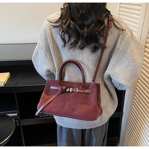 Close-up of matte wine red tote bag with belt buckle detail shown on a model's back