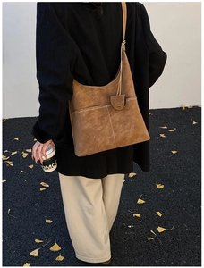 Detail of dark brown suede Hobo bag featuring white contrast stitching and accessory pocket