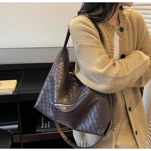 Detail of dark brown woven texture on a large hobo shoulder bag with a zipper design