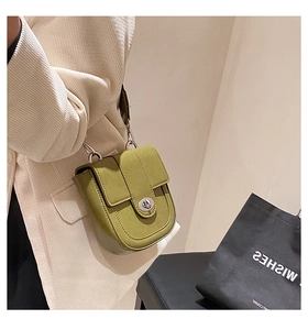 Détail du sac bandoulière vert avec fermoir pivotant argenté et sangle en cuir