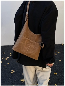 Detailed view of vintage amber PU leather crossbody bag with decorative white stitching