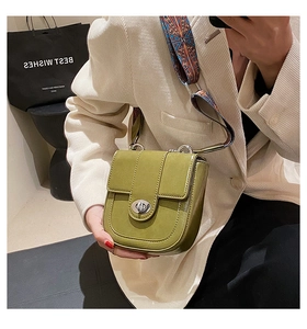 Détail du sac bandoulière vert olive avec sangle large à motifs et fermoir ovale argenté