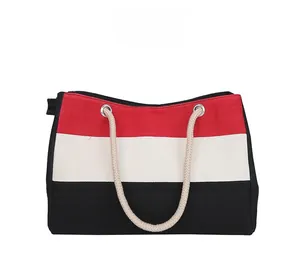 Detail der Canvas-Tasche mit rot-weiß-schwarzen Streifen und Seil-Handgriffen