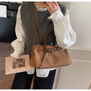 Brown faux suede tote bag with leather buckle detail worn as a vintage crossbody bag